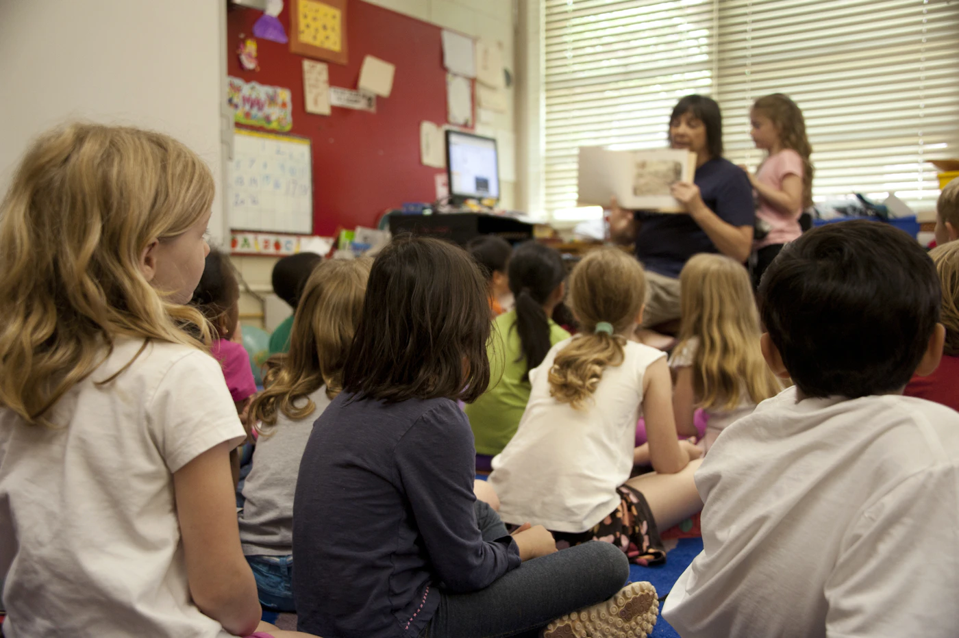 Kinder hören gemeinsam einer Geschichte im Klassenraum zu